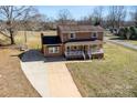 Two story brick home with mature landscaping and a long driveway on a sunny day at 305 Plantation Dr, Kings Mountain, NC 28086