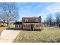 Traditional brick home featuring a cozy covered front porch and lush green lawn at 305 Plantation Dr, Kings Mountain, NC 28086