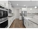 Modern kitchen features white cabinets, stainless steel appliances, and granite countertops at 3212 Burnello Ct, Iron Station, NC 28080