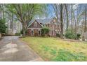 Attractive brick home showcases mature trees, a well-kept lawn, and a long driveway at 3400 Thistle Bloom Ct, Charlotte, NC 28269