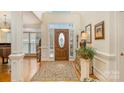 Bright foyer features a soaring ceiling, hardwood floors, an oval front door with sidelights, and elegant decor at 4828 Beth Ln, Harrisburg, NC 28075