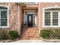 Elegant front entrance with brick steps, black door, and sidelight windows at 4828 Beth Ln, Harrisburg, NC 28075
