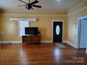 Bright living room features hardwood floors, ceiling fan and front door with oval window at 516 W 7Th St, Kannapolis, NC 28081
