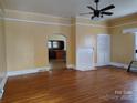 Spacious living room featuring hardwood floors, ceiling fan and white fireplace at 516 W 7Th St, Kannapolis, NC 28081