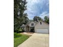 Attractive exterior elevation featuring a front-entry garage, a curved walkway, and neutral colored siding at 7306 Timbercreek Ct, Denver, NC 28037