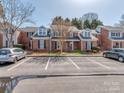 Exterior view of red brick townhomes, parking area and manicured lawns in residential neighborhood at 9128 Kings Canyon Dr, Charlotte, NC 28210