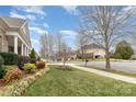 Picturesque neighborhood street view showcasing well-maintained lawns, mature trees, sidewalks and beautifully landscaped homes at 9795 Shearwater Nw Ave, Concord, NC 28027