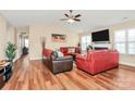 Comfortable living room with a fireplace, ceiling fan and hardwood floors at 15707 Southern Garden Ln, Charlotte, NC 28278