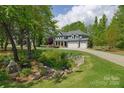 Spacious two-story home with inviting curb appeal, featuring a long driveway and lush landscaping at 158 Country Lake Dr, Mooresville, NC 28115