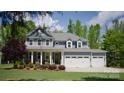 Inviting two-story home with a covered porch, well-manicured lawn, and a three-car garage at 158 Country Lake Dr, Mooresville, NC 28115