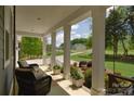 Inviting front porch with comfortable seating, framed by classic white columns and beautiful landscaping at 158 Country Lake Dr, Mooresville, NC 28115