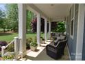 Cozy front porch featuring a swing, comfortable seating, and manicured landscaping at 158 Country Lake Dr, Mooresville, NC 28115