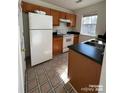 Efficient kitchen features a white refrigerator, electric range, wood cabinets, and laminate countertops at 1754 Pergola Pl, Charlotte, NC 28213