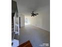 Spacious, carpeted living room features a ceiling fan and natural light through a glass door at 1754 Pergola Pl, Charlotte, NC 28213