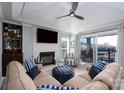 This cozy living room includes a stone fireplace, comfortable seating, and a sliding door to a balcony at 18877 Vineyard Point Ln, Cornelius, NC 28031