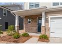 Inviting front porch with brick columns, well-lit entry and manicured landscaping leading to front door at 2032 Bexar Trl, Matthews, NC 28105