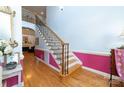 Bright foyer features hardwood floors, staircase with black iron railings and vibrant pink accent wall with white wainscoting at 205 Kaitlyn Ln, Kings Mountain, NC 28086