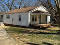 Home's exterior with neutral siding, a covered porch, and modest landscaping on a sunny day at 216 W Shannonhouse St, Shelby, NC 28152