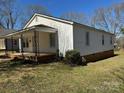 Side view of home featuring neutral siding and a covered porch with decorative iron supports at 216 W Shannonhouse St, Shelby, NC 28152