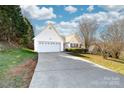 Charming home featuring an attached two-car garage, white siding, and a well-maintained front yard with lush greenery at 2359 Eagle Glen Ct, Gastonia, NC 28056