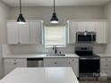 Modern kitchen featuring white cabinets, quartz countertops, stainless appliances, and sleek black pendant lighting at 3342 York Hwy, Gastonia, NC 28052