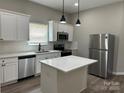 Bright kitchen boasts stainless steel appliances, white cabinets, and an island with a quartz countertop at 3342 York Hwy, Gastonia, NC 28052