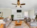 Bright living room featuring a brick fireplace, ceiling fan and neutral decor at 414 N Wylie St, Lancaster, SC 29720