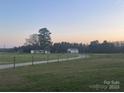Charming exterior view of a home with a gravel driveway, outbuilding, surrounded by a green lawn at twilight at 485 Harper Miller Dr, Cleveland, NC 27013