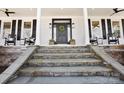Inviting front porch features stone steps, classic rocking chairs, and a stylish front door with wreath at 607 Beaten Path Rd, Mooresville, NC 28117