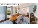 Bright dining room with a modern chandelier, large window, and a stylish area rug at 7021 Sylvan Retreat Dr, Denver, NC 28037