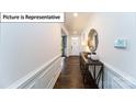 Inviting foyer with hardwood floors, wainscoting, and a decorative mirror above a console table at 7021 Sylvan Retreat Dr, Denver, NC 28037