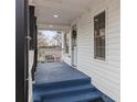 View of the covered front porch with white railings, black pillars, and a charming front door at 98 Ring Sw Ave, Concord, NC 28025