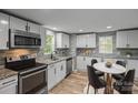 Eat-in kitchen featuring stainless steel appliances, granite counters, and stylish tile backsplash at 98 Ring Sw Ave, Concord, NC 28025