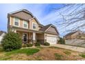 A view of a two-story home with a two car garage, well-maintained lawn, and a welcoming porch at 10605 Three Rivers Ct, Charlotte, NC 28273