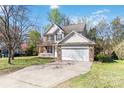 Charming two-story home features a brick and siding facade, attached garage, and well-manicured lawn at 10820 Hunters Trace Ct, Charlotte, NC 28262