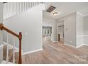 Bright entryway featuring hardwood floors, a staircase with white railings and a view to the living spaces at 10933 Sedgemoor E Ln, Charlotte, NC 28277