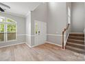 Open-concept entryway with hardwood flooring, a staircase with carpeted treads, and high ceilings for a grand entrance at 10933 Sedgemoor E Ln, Charlotte, NC 28277