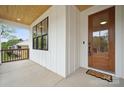 Inviting front porch features a wood ceiling, large window and a glass paneled front door at 1210 Skyview Rd, Charlotte, NC 28208