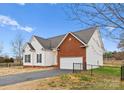 Charming home features vinyl siding, brick accents, attached garage, and well-maintained lawn at 134 Falling Leaf Ln, Statesville, NC 28677