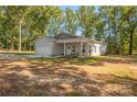 A charming single-story house featuring a covered front porch and attached garage, nestled among mature trees at 1513 Fletcher Broome Rd, Monroe, NC 28112