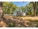 Lovely single-story home with attached garage and covered porch, framed by mature trees and a gravel driveway at 1513 Fletcher Broome Rd, Monroe, NC 28112