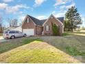 Brick home with a well-maintained lawn and a silver car parked in the driveway at 1896 Independence Sq, Kannapolis, NC 28081