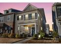 Charming two-story home with gray shutters, covered front porch, and landscape lighting at 2147 Stevens Mill Rd, Matthews, NC 28104