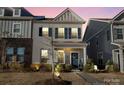 Charming two-story home with gray shutters, covered front porch, and landscape lighting at 2147 Stevens Mill Rd, Matthews, NC 28104