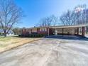 Charming brick ranch-style home featuring a carport and long driveway on a sunny day at 2310 Clay St, Kannapolis, NC 28083