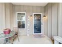 Cozy front porch featuring a quaint seating area, a decorative welcome sign, and stylish outdoor lighting fixtures at 255 Dorothy Dr, China Grove, NC 28023