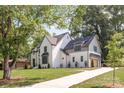 Beautiful white painted brick home with a walkway and a large well-maintained lawn and mature trees at 5124 Lansing Dr, Charlotte, NC 28270
