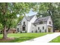 Beautiful white brick home with manicured lawn, mature trees, and modern gray accents on windows at 5124 Lansing Dr, Charlotte, NC 28270