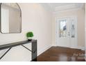Entryway featuring a dark wood floor, white trim, console table, and modern mirror at 5367 Heartwood Ln, Denver, NC 28037
