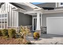 Home's inviting entrance with stone accents on siding and columns along with a well manicured garden at 5367 Heartwood Ln, Denver, NC 28037